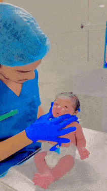 a newborn baby is being examined by a doctor in a hospital room