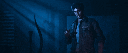 a man standing in a dark room with the word police on his shirt