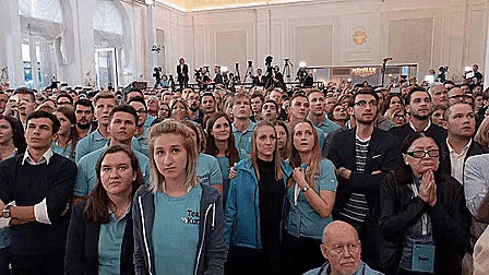 a group of people are gathered in a room and one of them is wearing a t-shirt that says " team world "