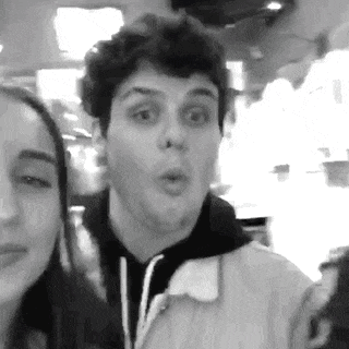 a man and a woman are posing for a picture in a black and white photo .