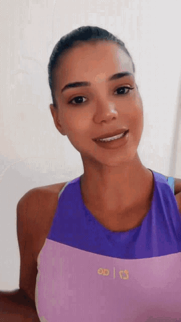 a woman is wearing a purple tank top with the letters od on it