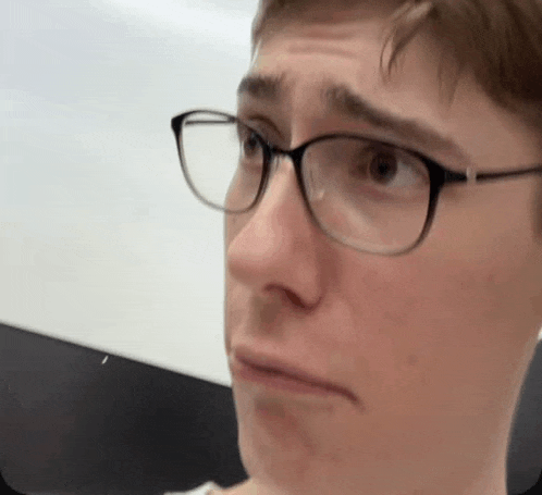 a close up of a man wearing glasses making a face .