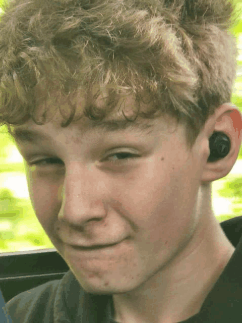 a young boy wearing a pair of ear buds