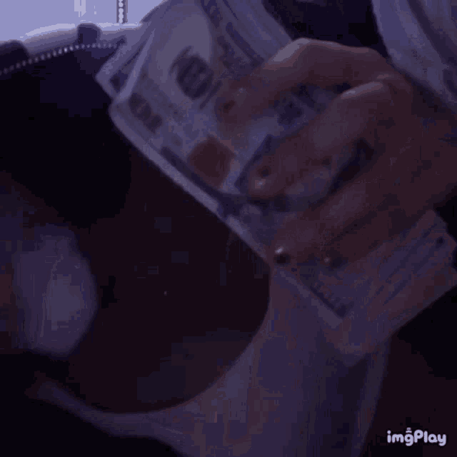 a person is holding a large stack of money in their hands .