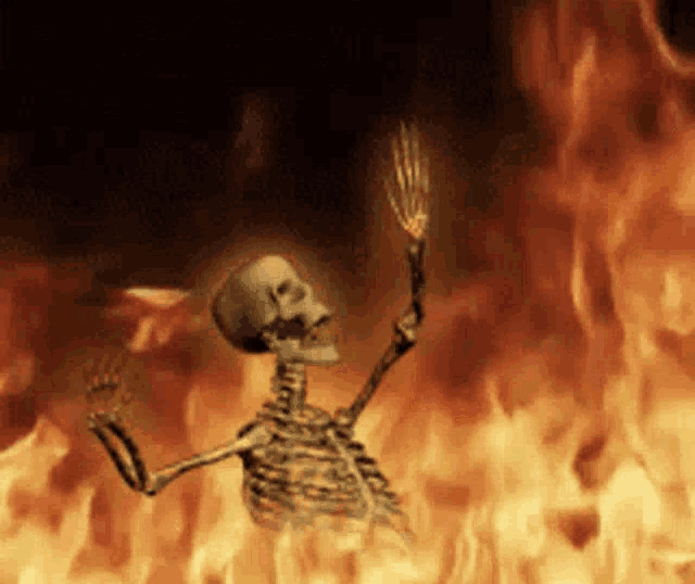 a skeleton is standing in a fire holding a torch