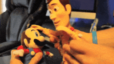 a person is holding a mario and woody doll