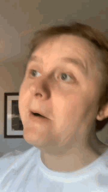 a man in a white shirt is making a funny face with his mouth open