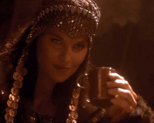 a woman wearing a headband with coins on it looks down at something