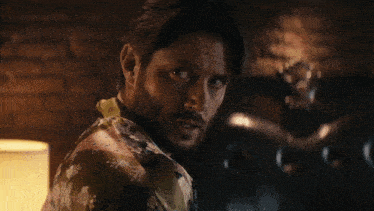 a man with a beard is wearing a colorful shirt