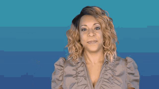 a woman is making a funny face while wearing a ruffled shirt .