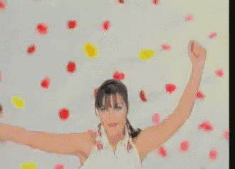 a woman with her arms outstretched is surrounded by petals