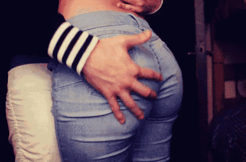 a man 's hand is on the back of a woman 's butt