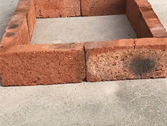 a square of bricks is sitting on the ground