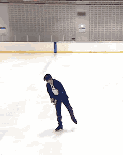 a man in a suit stands on a ice rink
