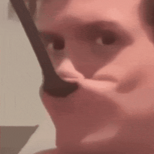 a man is brushing his teeth with a toothbrush in a close up of his face