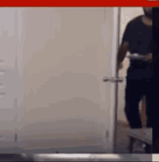 a man is standing in a doorway holding a tray .