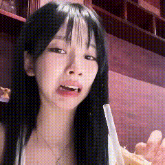 a close up of a woman with long black hair holding a straw in her mouth .