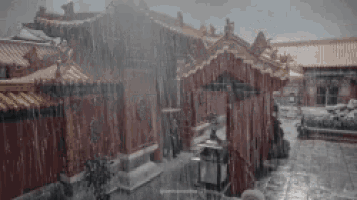 it is a very rainy day in a chinese city with a lot of rain falling on the buildings .