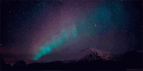 the aurora borealis shines brightly in the night sky over a snowy mountain