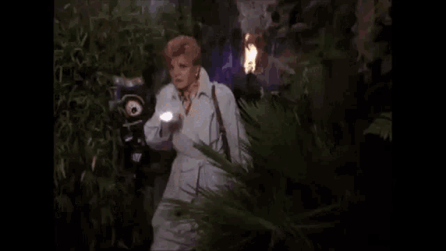 a woman in a white coat is holding a glowing object in her hand .