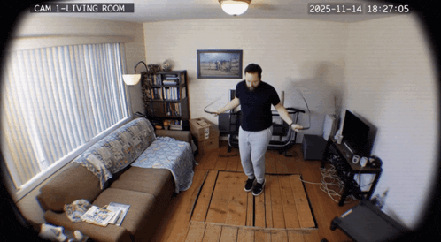 a man is jumping a jump rope in a living room with a date stamp of 2025-11-14