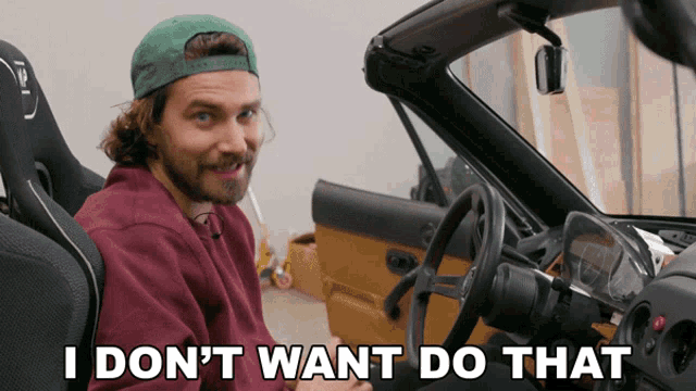 a man sitting in a car with the words " i don 't want do that " written on the bottom