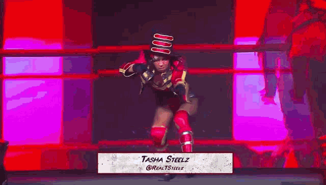 a woman in a top hat is dancing on a stage in front of a flag .