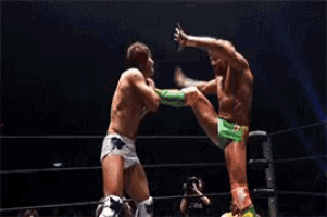 two men are wrestling in a ring and one of them is wearing green boots