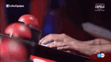 a close up of a person 's hands on a keyboard with the words la voz equipos in the corner