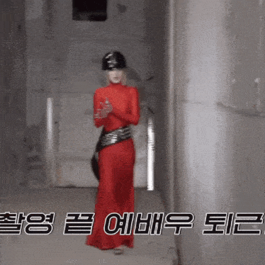 a woman in a red dress and black helmet is standing in a hallway with chinese writing