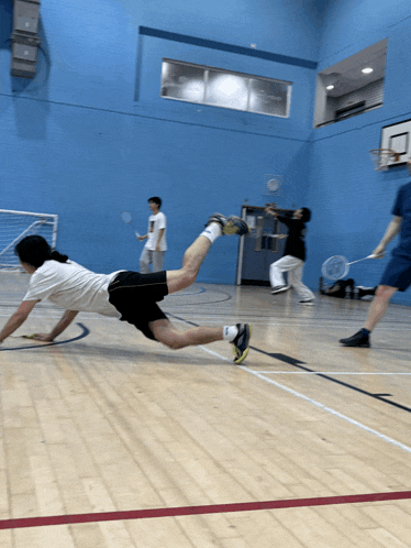 a group of people are playing badminton on a court