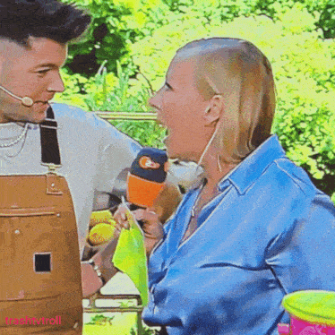 a woman screams into a microphone while talking to a man with a microphone on his head
