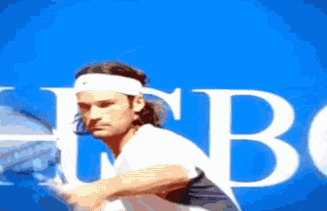 a man in a white headband is holding a tennis racquet in front of a blue background with the letter b visible