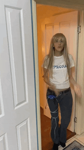a woman in a pepsi cola shirt is standing in a hallway