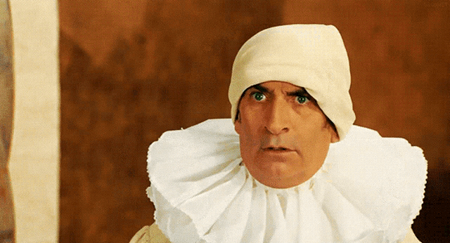 a man wearing a white hat and a white collar looks surprised