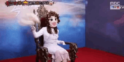 a woman in a white dress is sitting in a chair with a mask on her face .