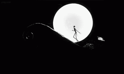 a black and white photo of a skeleton standing in front of a large white moon .