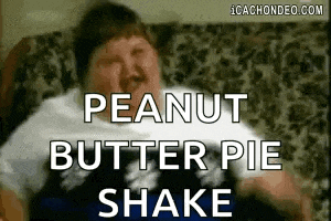 a man is sitting on a couch with a peanut butter pie shake .
