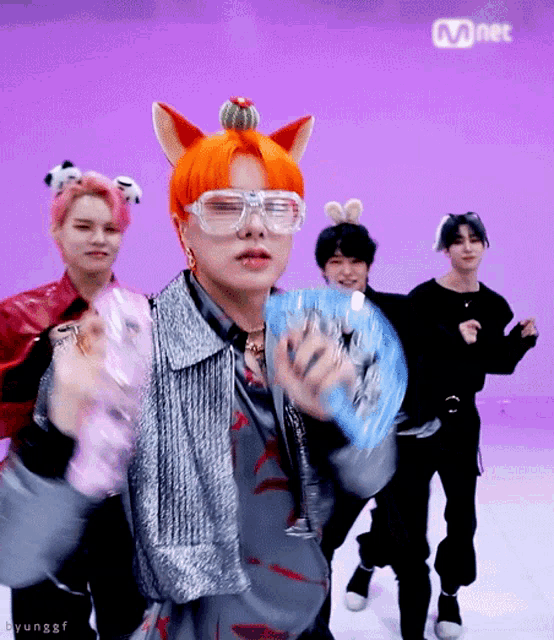 a group of young men are dancing in front of a purple background that says mnet on it