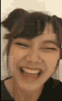 a close up of a woman laughing with her eyes closed