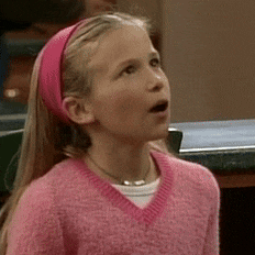 a little girl wearing a pink headband and a pink sweater