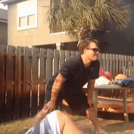 a man in sunglasses is kneeling down next to a woman
