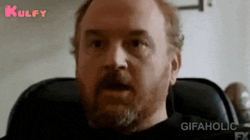 a man with a beard is sitting in a chair and looking at the camera .