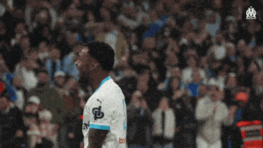 a soccer player is standing in front of a crowd while wearing a white and blue jersey with the number 8 on it