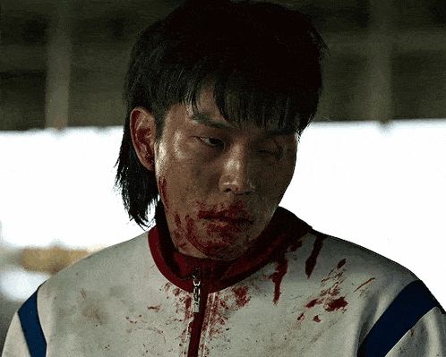 a man with blood on his face wearing a white jacket