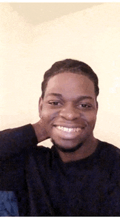 a man with a beard is smiling and holding his neck