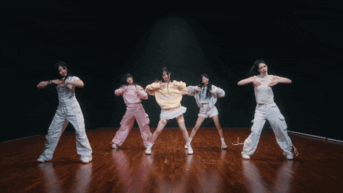a group of young women are dancing on a stage and one of them is wearing a shirt that says ' i love you '