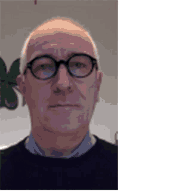 a man wearing glasses and a black sweater looks at the camera .