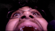 a man with glasses and a beard is making a funny face