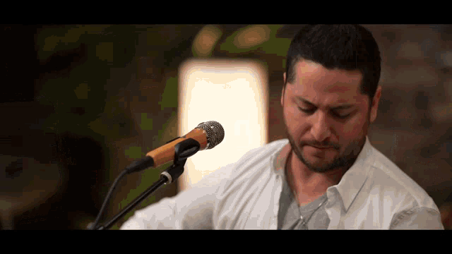 a man singing into a microphone while holding a guitar